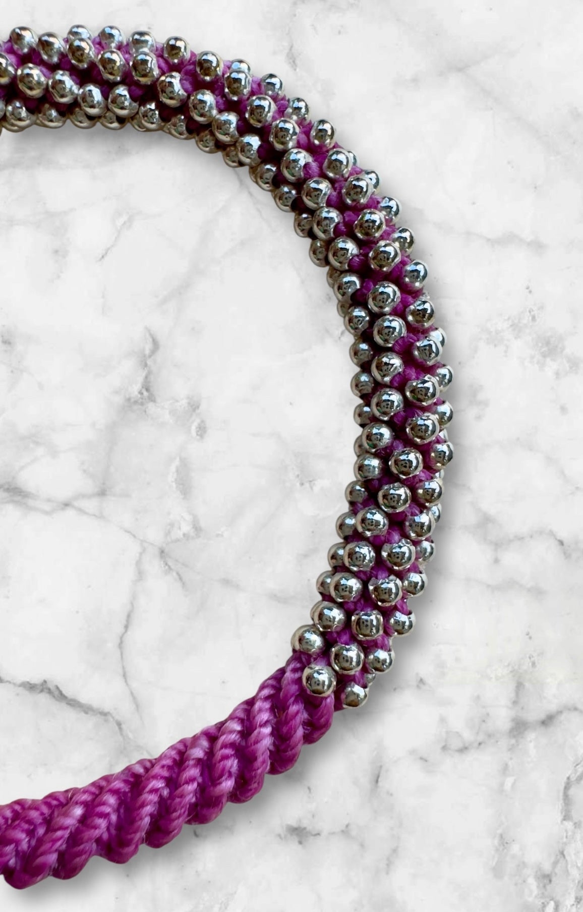 Handgeknüpftes Armband aus 240 Silberperlen mit violettem Makrameeband auf Marmorhintergrund – Zyklus der Zeit 240
